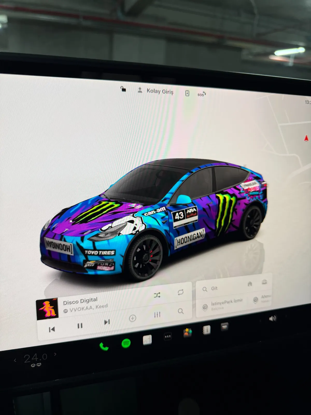 Tesla large screen showing custom Hoonigan Ken Block themed vehicle wrap - side view